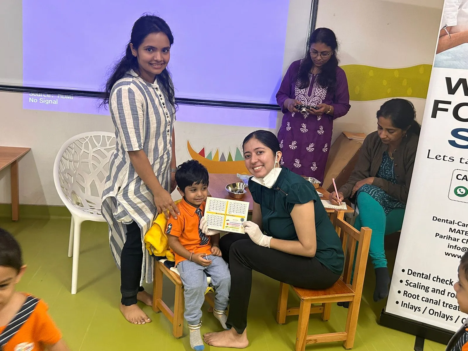 Dentist handing a brushing calendar to a young boy to encourage good oral hygiene habits.