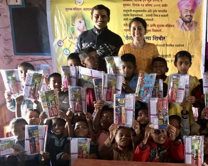 Volunteers distributing oral hygiene kits to children at the outreach camp