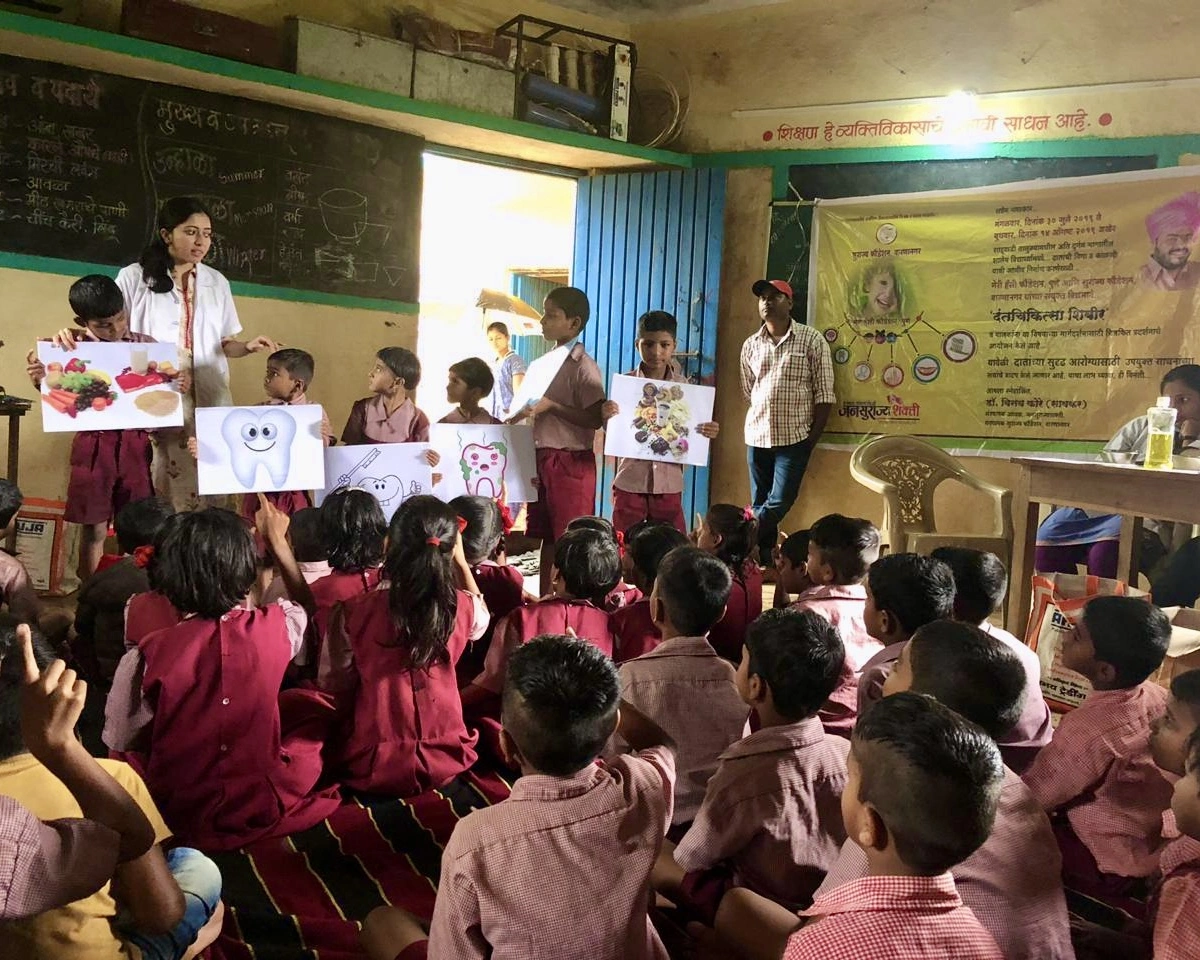 Dentist teaching children about healthy foods for strong teeth and better oral health.