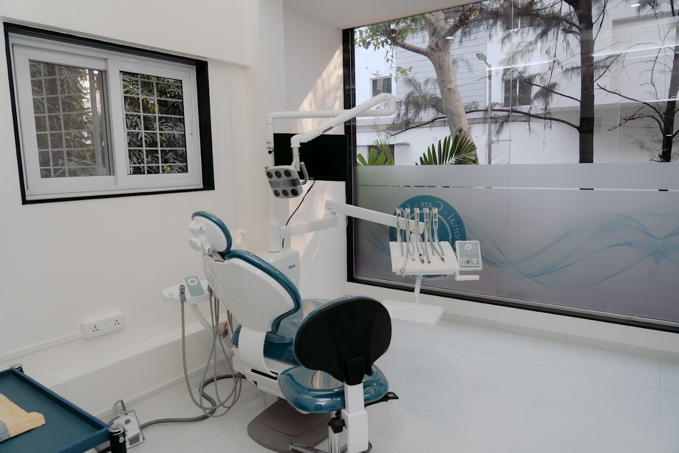 A wide view of a dental clinic room featuring a treatment chair and modern facilities