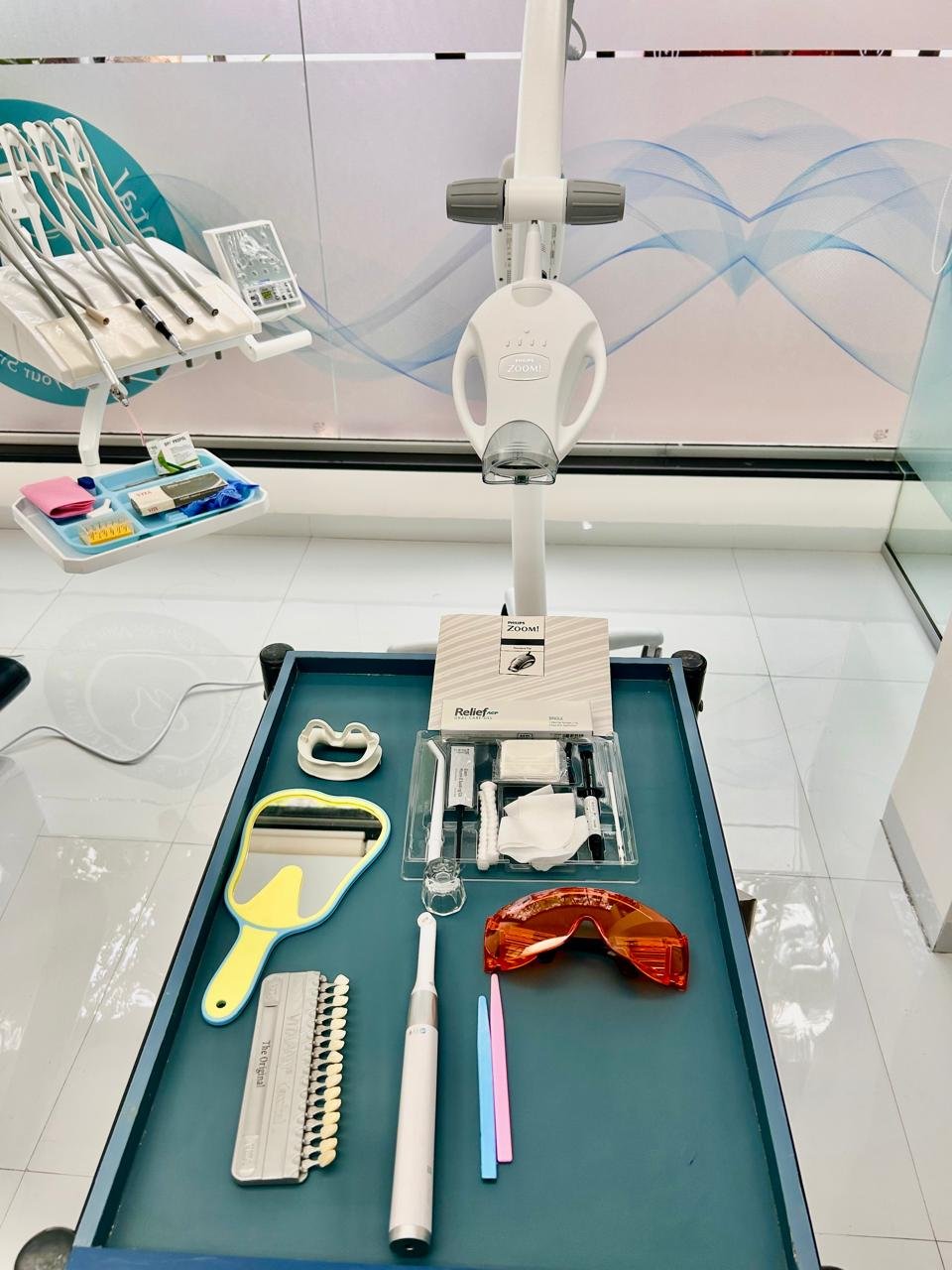 Teeth whitening equipment including LED light and dental tools arranged on a clean surface