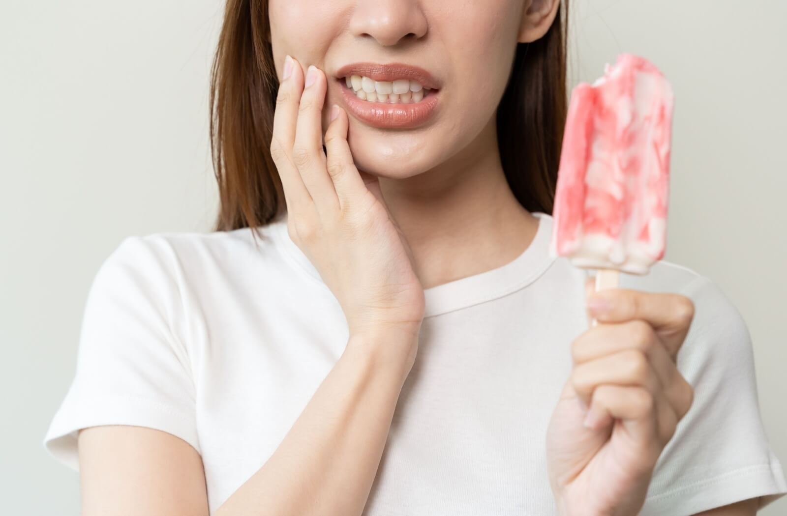 Woman with sensitive teeth reacting to cold food discomfort
