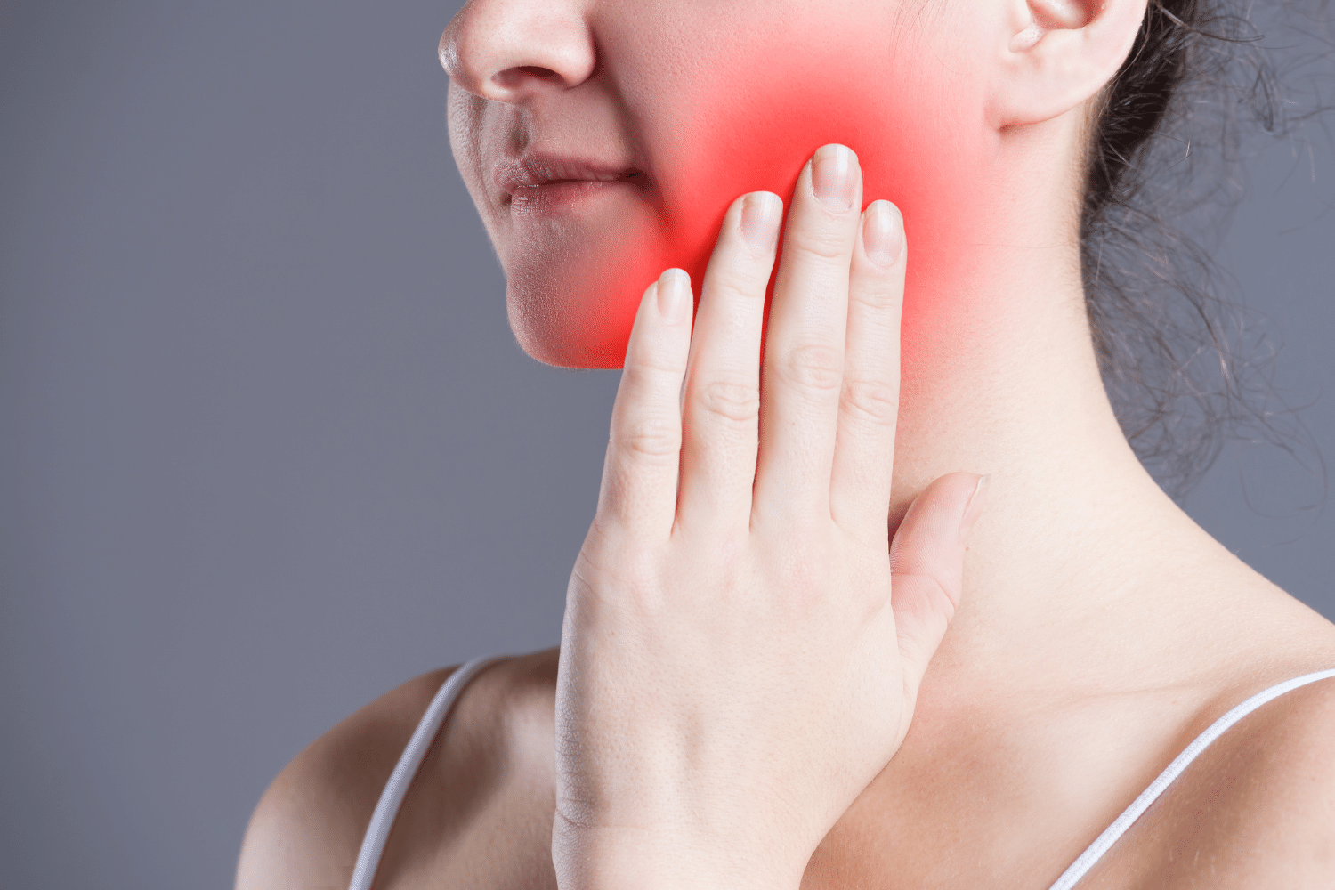 Women with severe toothache holding cheek – example of dental emergency.